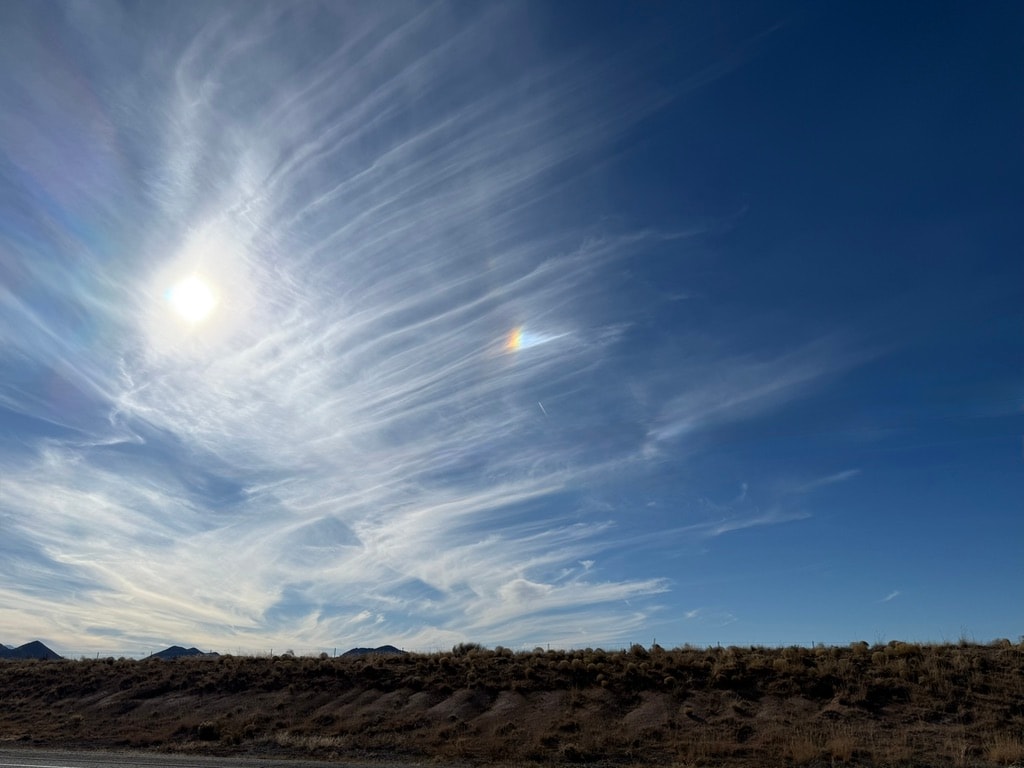 Open blue sky with wisps of cloud and sunlight